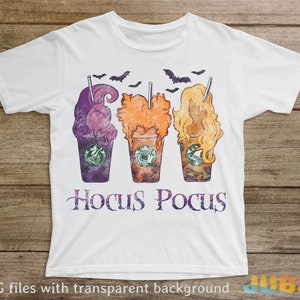 May include: White t-shirt featuring a design of three Halloween-themed coffee cups with the text "Hocus Pocus" below.