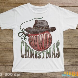 May include: White t-shirt with a vintage-style graphic of a red Christmas ornament with a cowboy hat and the text "Howdy Christmas".