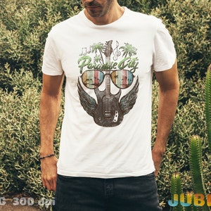 May include: White t-shirt with a graphic of a guitar wearing sunglasses and the text "Paradise City".
