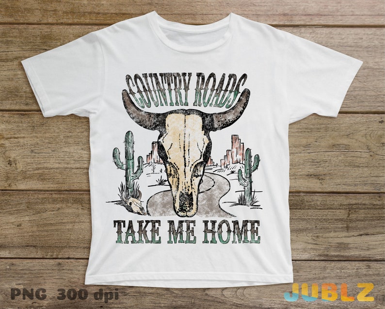 May include: White t-shirt with a vintage-style graphic of a skull with horns, cacti, and a road. The text "COUNTRY ROADS TAKE ME HOME" is printed below the graphic.