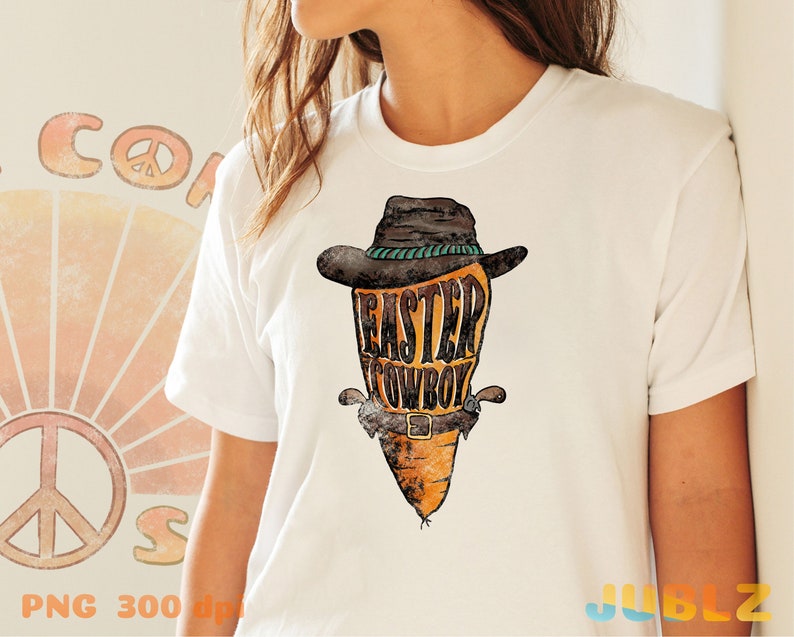 May include: White t-shirt with a graphic of a carrot wearing a cowboy hat and a belt with the text "Easter Cowboy".