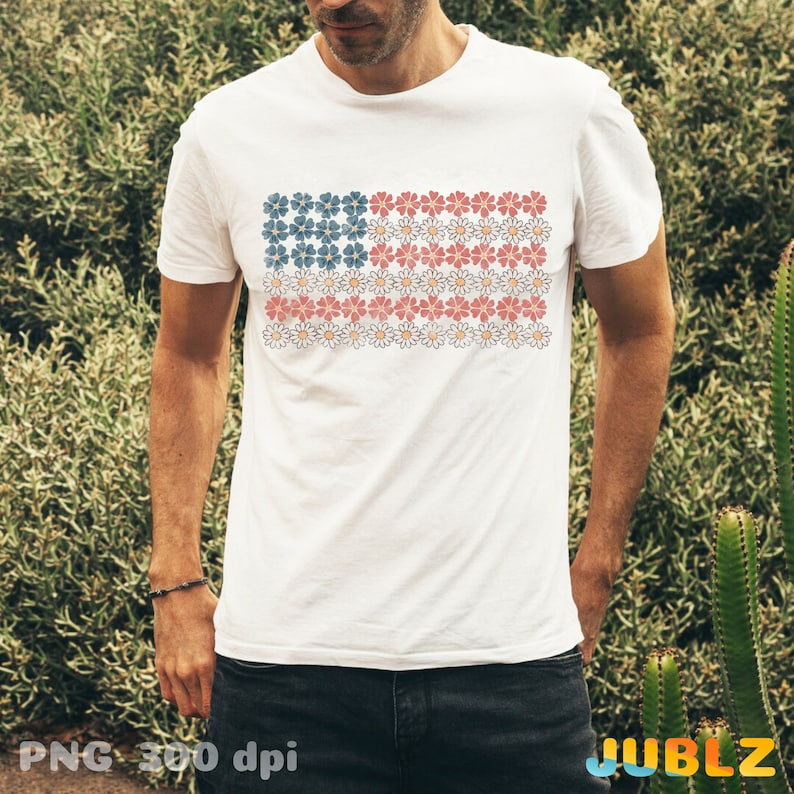 May include: White t-shirt with a red, white, and blue American flag design made of flowers. The flag is centered on the shirt.