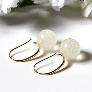 Pendientes colgantes con gancho en forma de C y bolas blancas brillantes. Pendientes de bola de cubo.