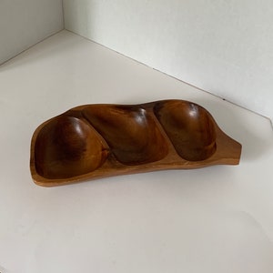May include: A wooden serving tray with three separate compartments. The tray is made of dark brown wood and has a natural, rustic look.