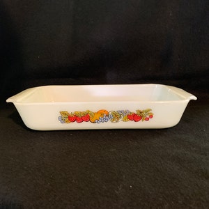 May include: White rectangular baking dish with a fruit design. The design features strawberries, grapes, and an orange.