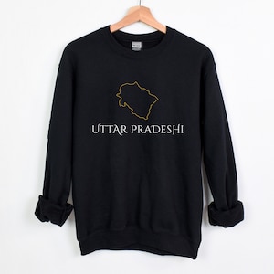 May include: Black sweatshirt with a gold outline of the state of Uttar Pradesh and the text "UTTAR PRADESHI" in white.