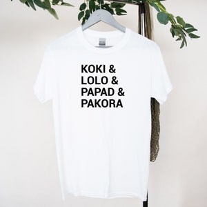 May include: White t-shirt with black text that reads "Koki & Lolo & Papad & Pakora"