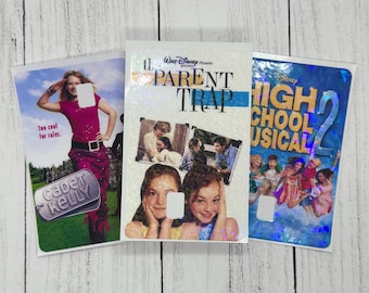 May include: Three DVD movie covers: "Cadet Kelly", "The Parent Trap", and "High School Musical 2". The "Cadet Kelly" cover features a woman in a pink outfit. "The Parent Trap" has photos of two girls. "High School Musical 2" has a group of people.