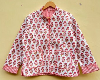 May include: A white quilted jacket with a pink floral print and red and white striped trim. The jacket has a button closure and two pockets.