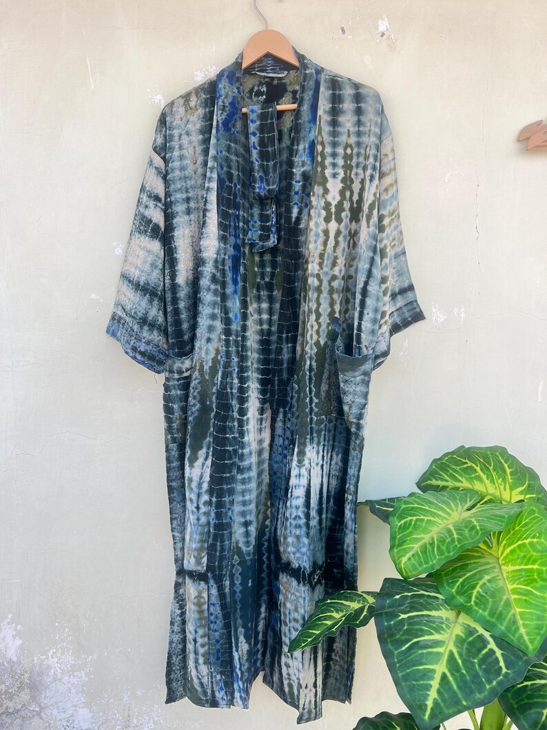 K&ouml;nnte beinhalten: Ein langer, blau-gr&uuml;ner Batik-Kimono mit einem G&uuml;rtel. Der Kimono hat eine lockere Passform und ist aus einem leichten Stoff gefertigt.