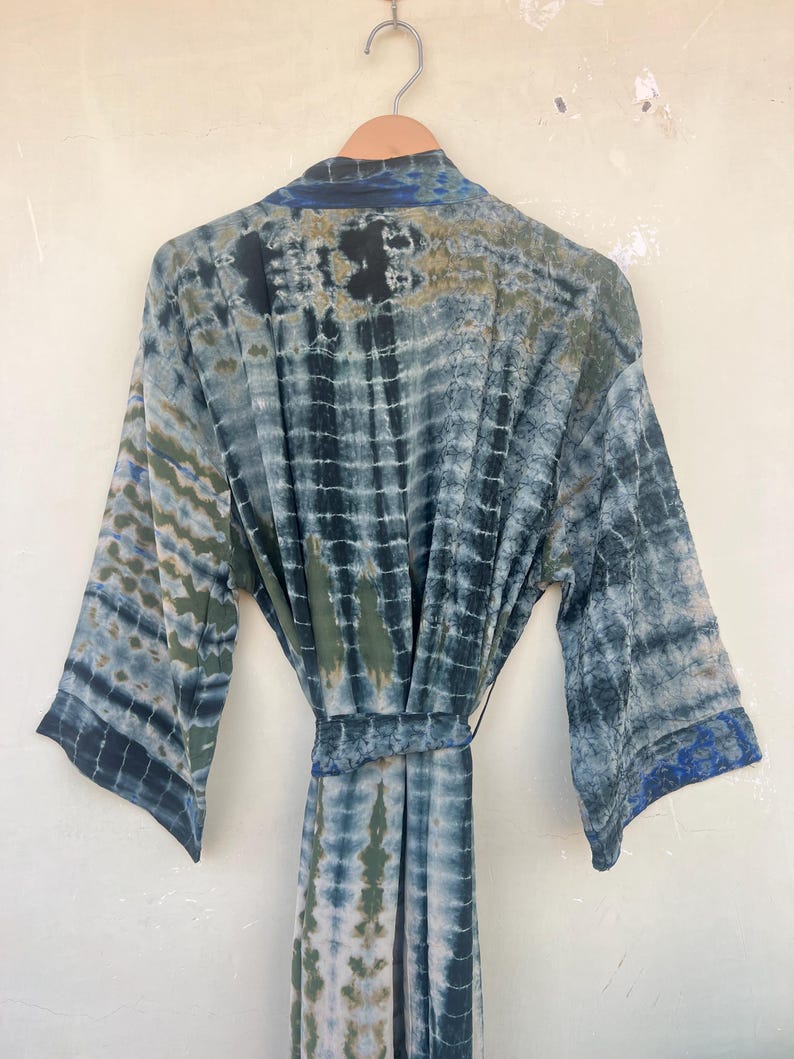 K&ouml;nnte beinhalten: Eine blaue und gr&uuml;ne Batik-Seidenrobe mit langen &Auml;rmeln und einem Bindeg&uuml;rtel.