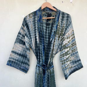 K&ouml;nnte beinhalten: Eine blaue und gr&uuml;ne Batik-Seidenrobe mit langen &Auml;rmeln und einem Bindeg&uuml;rtel.