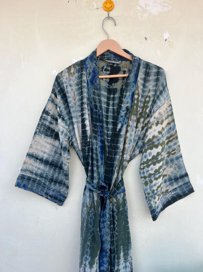 K&ouml;nnte beinhalten: Eine blaue und gr&uuml;ne Batik-Seidenrobe mit langen &Auml;rmeln und einem Bindeg&uuml;rtel.