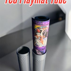 May include: A gray and white tube with a black and purple playmat rolled inside. The playmat has a colorful illustration of a cartoon character with a red nose and a white beard. The tube has a textured surface and the text "RetroJoe3D" is printed on the bottom.