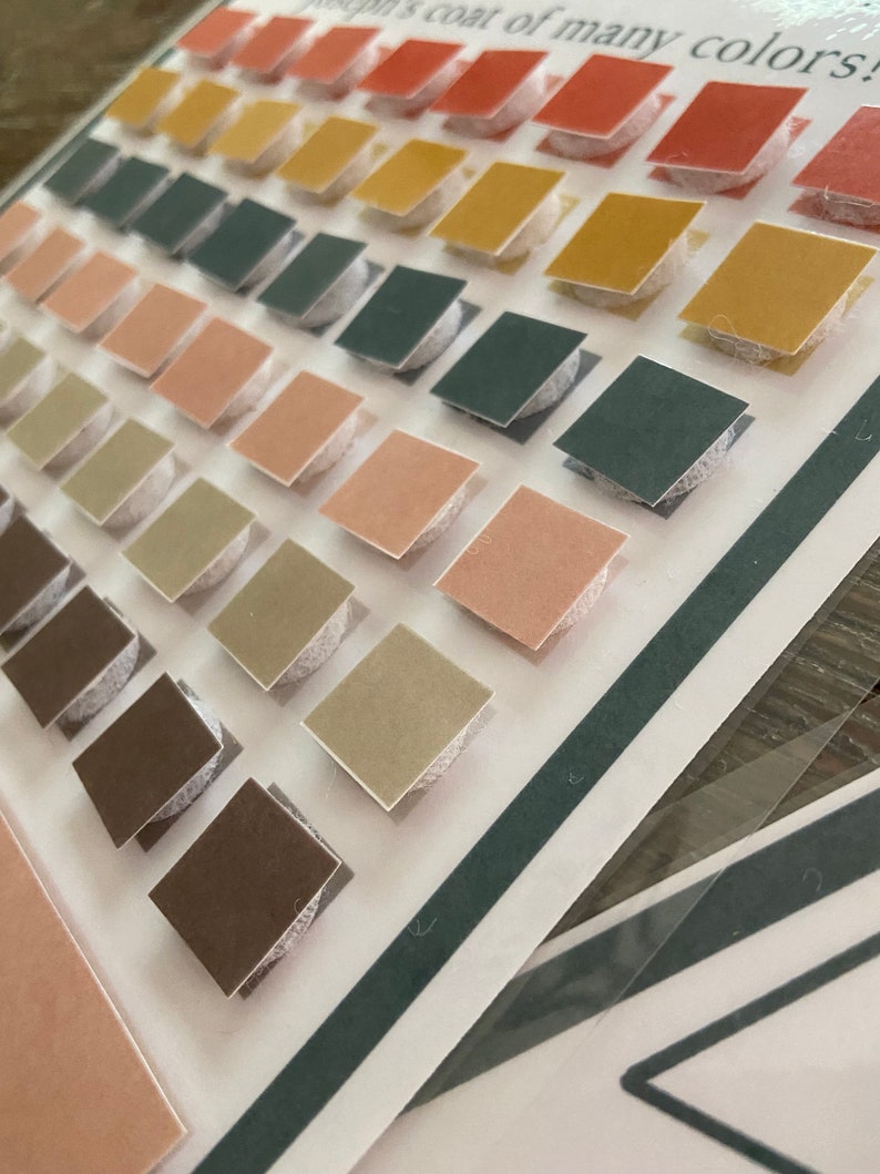 May include: A set of colourful squares with adhesive backing. The squares are arranged in rows, with each row featuring a different colour. The colours include red, orange, yellow, green, blue, and brown. The squares are perfect for crafting and decorating.