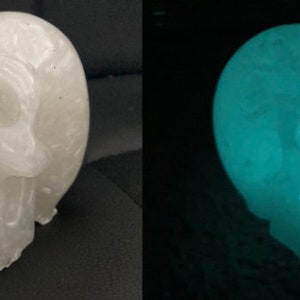 Könnte beinhalten: Eine weiße Schädelskulptur aus einem leuchtenden Material. Der Schädel leuchtet im Dunkeln hellgrün.
