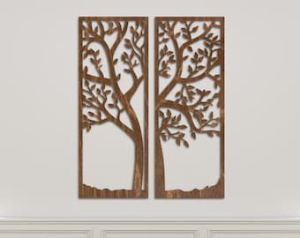 May include: Two wooden wall decor panels featuring a cutout design of a tree with branches and leaves. The panels are brown and are mounted on a white wall.