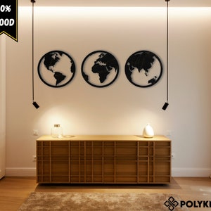 May include: Three black wooden wall decorations shaped like the Earth, hanging on a white wall with a wooden dresser underneath. The text "100% WOOD" is in the top left corner of the image.