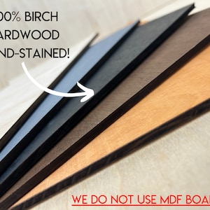 May include: Close-up of several hand-stained birch hardwood boards in varying shades of brown, black, and gray. The text "100% BIRCH HARDWOOD HAND-STAINED!" is displayed in white, with an arrow pointing to the boards. The text "WE DO NOT USE MDF BOARD" is displayed in red.