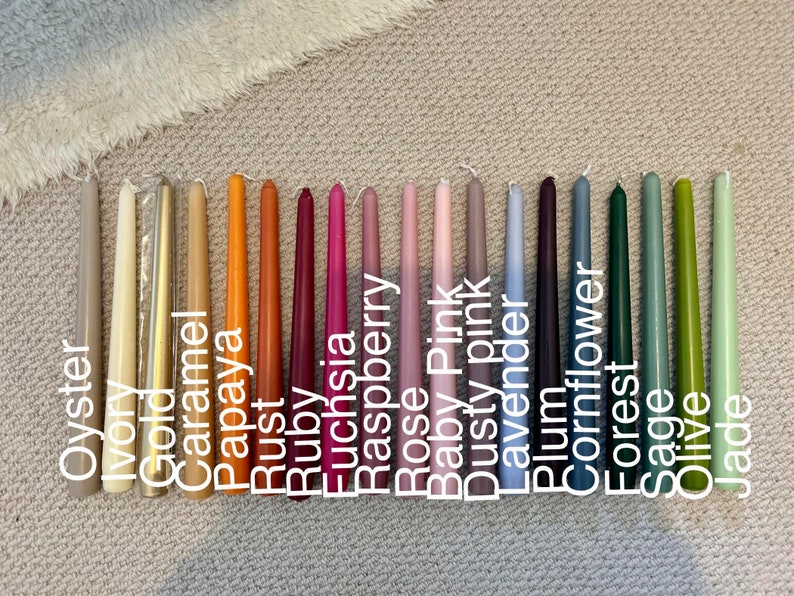 K&ouml;nnte beinhalten: Eine Sammlung von achtzehn Stabkerzen in einem Farbspektrum, darunter Oyster, Ivory, Gold, Caramel, Papaya, Rust, Ruby, Fuchsia, Raspberry, Rose, Baby Pink, Dusty Pink, Lavender, Plum, Cornflower, Forest, Sage, Olive und Jade.