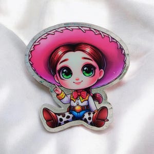May include: A cartoon illustration of a girl wearing a pink cowboy hat and a brown and blue cowboy outfit. She has large green eyes and brown hair. The illustration is on a white background.