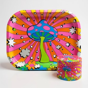 May include: A colorful, retro-style tray and grinder set. The tray features a large mushroom design with a blue cap and pink spots, set against a vibrant orange and pink background with star and cloud accents. The grinder has a matching design.