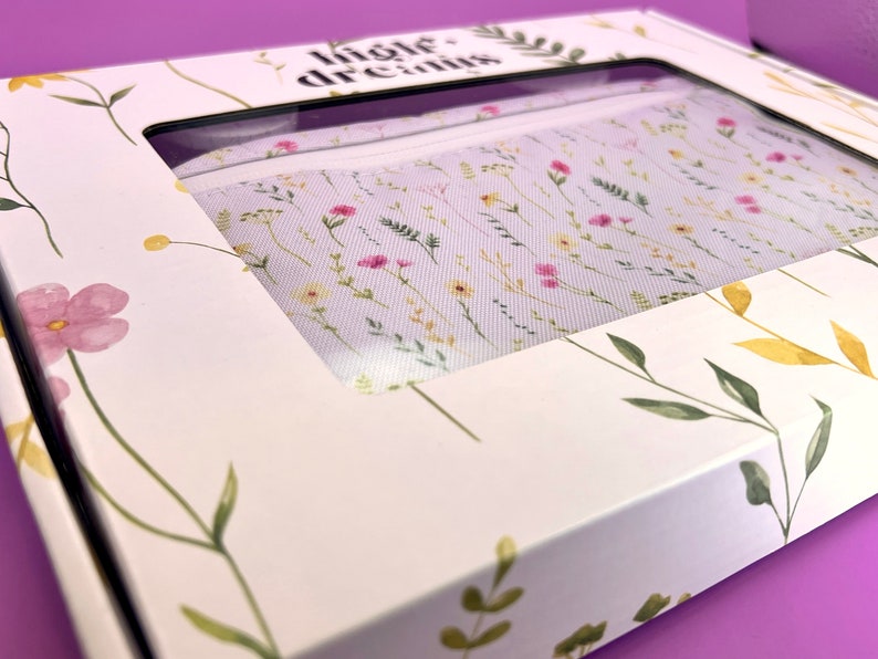 Peut inclure: Une bo&icirc;te blanche avec un motif floral et le texte "little dreams" imprim&eacute; sur le dessus. La bo&icirc;te est ouverte et une pochette en tissu blanc avec un motif floral est visible &agrave; l'int&eacute;rieur.