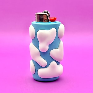 May include: A blue lighter with a white cloud pattern. The lighter has a silver top and a red button.