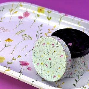 Peut inclure: Un plateau en m&eacute;tal blanc avec un motif floral et un moulin &agrave; herbes en m&eacute;tal avec un couvercle &agrave; motif floral. Le moulin est ouvert et l'int&eacute;rieur est noir.