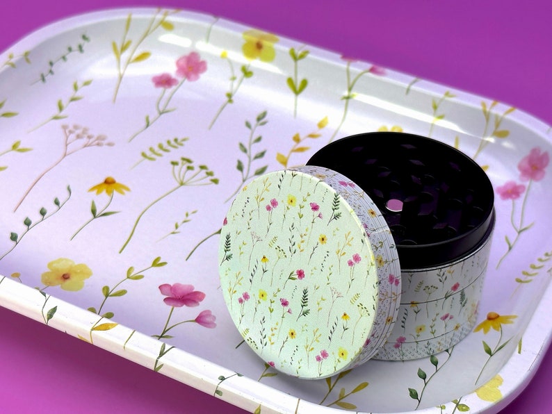 Peut inclure: Un plateau en m&eacute;tal blanc avec un motif floral et un moulin &agrave; herbes en m&eacute;tal avec un couvercle &agrave; motif floral. Le moulin est ouvert et l'int&eacute;rieur est noir.