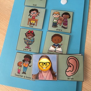 Op de afbeelding: Een lichtblauwe map met een witte klittenbandstip, met verschillende groene kaarten. De kaarten bevatten illustraties en tekst zoals "look", "help", "share", "pack up", "learning", "Teacher is boss" en "listen".
