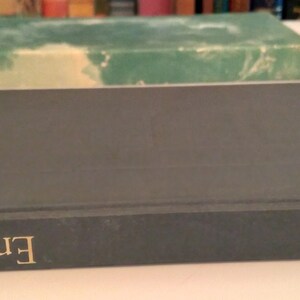 May include: A dark blue hardcover book with the title "Essays" in gold lettering on the spine. The author's name, "Emerson", is printed in gold lettering on the front cover.