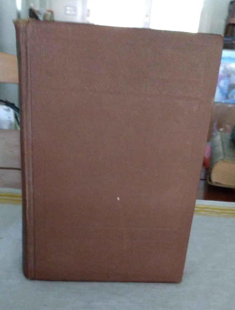 Pode incluir: Um livro de capa dura castanho com uma apar&ecirc;ncia desgastada. A capa do livro &eacute; de uma cor castanha lisa e suave, e a lombada &eacute; vis&iacute;vel no lado esquerdo. As bordas do livro mostram sinais de desgaste, sugerindo que &eacute; bem usado.