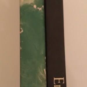 May include: Two hardcover books with green and black covers. The book on the left has a green cover with a swirling pattern and a white title. The book on the right has a black cover with the title "Essays" and the author's name "Emerson" in gold lettering.