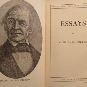 Pode incluir: Um livro aberto com um retrato de Ralph Waldo Emerson e a p&aacute;gina de t&iacute;tulo do seu livro "Essays". O retrato est&aacute; em uma moldura oval, e a p&aacute;gina de t&iacute;tulo inclui o texto "ESSAYS" e "RALPH WALDO EMERSON."