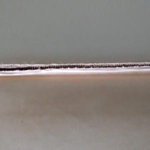 Pode incluir: Close-up das p&aacute;ginas de um livro, mostrando a borda das p&aacute;ginas e a encaderna&ccedil;&atilde;o. As p&aacute;ginas s&atilde;o de cor bege clara e a encaderna&ccedil;&atilde;o &eacute; marrom escuro. A borda das p&aacute;ginas &eacute; &aacute;spera e irregular.