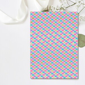 May include: A sheet of mermaid scale patterned paper with a turquoise, pink, and purple scale design. The scales are outlined in gold glitter.
