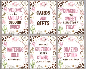 May include: Set of six themed signs with a cowgirl rodeo theme. Each sign features a brown and white cowhide pattern, pink text, and watercolor illustrations of cowboy hats, guitars, and cacti. Text includes "Welcome to Amelia's Second Rodeo."