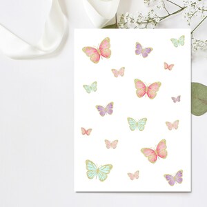 May include: A white card with a pattern of pink, purple, and blue butterflies with gold accents. The butterflies are of varying sizes and are scattered across the card.