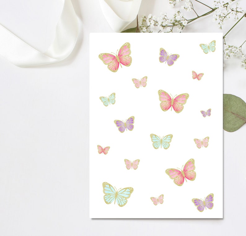 May include: A white card with a pattern of pink, purple, and blue butterflies with gold accents. The butterflies are of varying sizes and are scattered across the card.