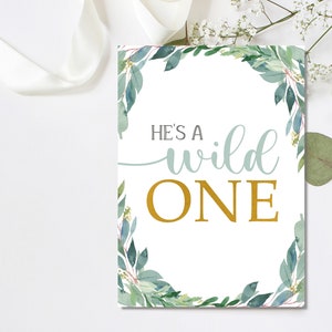 May include: A white sign with a green leafy border and the text "He's a wild one" in gold and blue lettering.