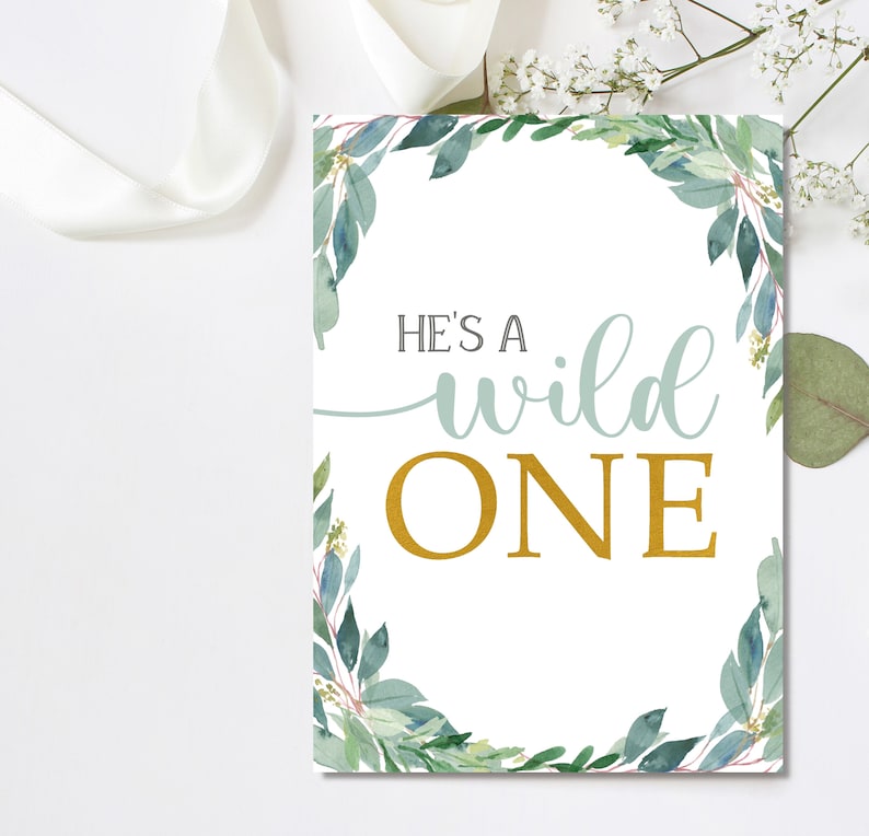 May include: A white sign with a green leafy border and the text "He's a wild one" in gold and blue lettering.