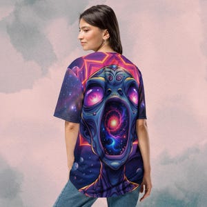May include: A purple and blue baseball jersey with a graphic print of an alien with a galaxy inside its mouth. The alien's eyes are glowing pink.