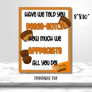 Puede incluir: Una impresión enmarcada con un borde naranja presenta el texto "Have we told you Reese-ently how much we appreciate all you do!" con gráficos de Reese's Peanut Butter Cup. La impresión mide 20,32 cm x 25,4 cm e incluye un gráfico de barra de chocolate "Yummy".
