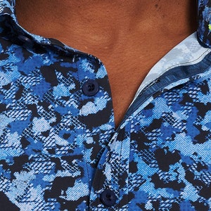 Pode incluir: Uma camisa azul e preta com bot&otilde;es e um padr&atilde;o de pele de cobra.