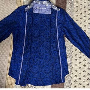 May include: A set of three ceramic mugs with a speckled, cream-colored glaze. Each mug features a different hand-painted floral design in shades of blue, green, and yellow. The mugs have a simple, rounded shape and a comfortable handle.