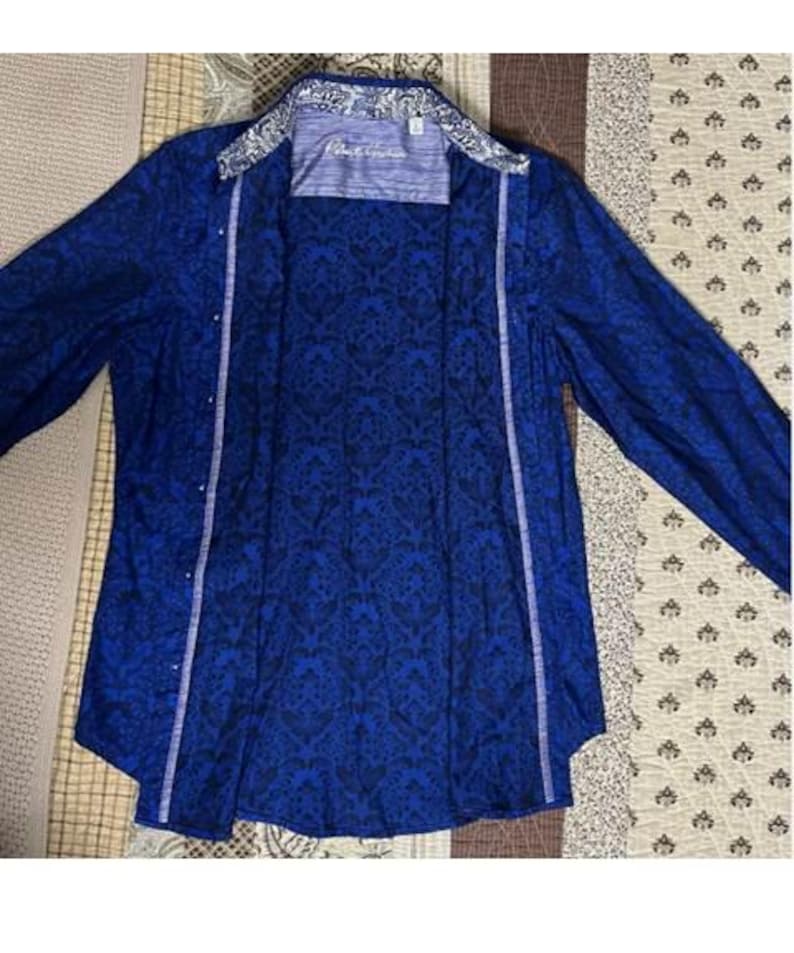 May include: A set of three ceramic mugs with a speckled, cream-colored glaze. Each mug features a different hand-painted floral design in shades of blue, green, and yellow. The mugs have a simple, rounded shape and a comfortable handle.