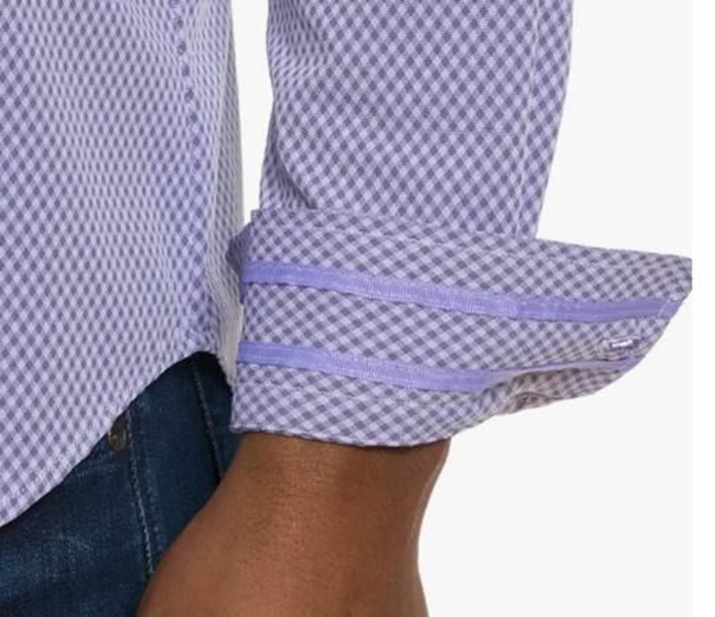 Puede incluir: Primer plano de una camisa de manga larga con un estampado de cuadros en morado claro y blanco. El pu&ntilde;o est&aacute; doblado, revelando un ribete liso en morado claro. La camisa se combina con vaqueros azules.
