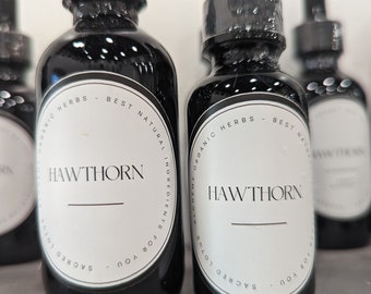 Könnte beinhalten: Mehrere dunkle Glasflaschen mit schwarzen Tropfern. Jede Flasche hat ein weißes Etikett mit dem Wort "HAWTHORN" in großen Buchstaben. Die Etiketten enthalten auch den Text "ORGANIC HERBS - BEST NATURAL INGREDIENTS FOR YOU".
