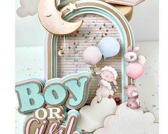 May include: A layered papercraft decoration with a pastel rainbow, moon, and clouds. The words "BOY OR GIRL" are prominently displayed. Includes a lamb, bear, and bunny with balloons. Gold accents and confetti add detail.